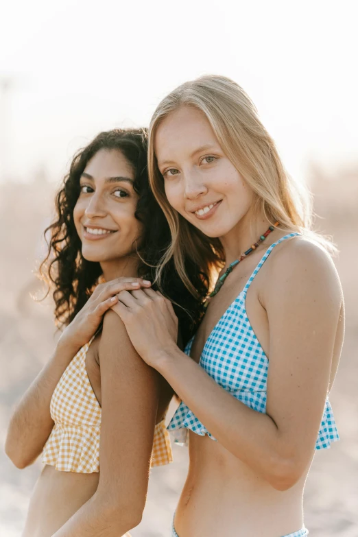 two girls standing next to each other in swimsuits