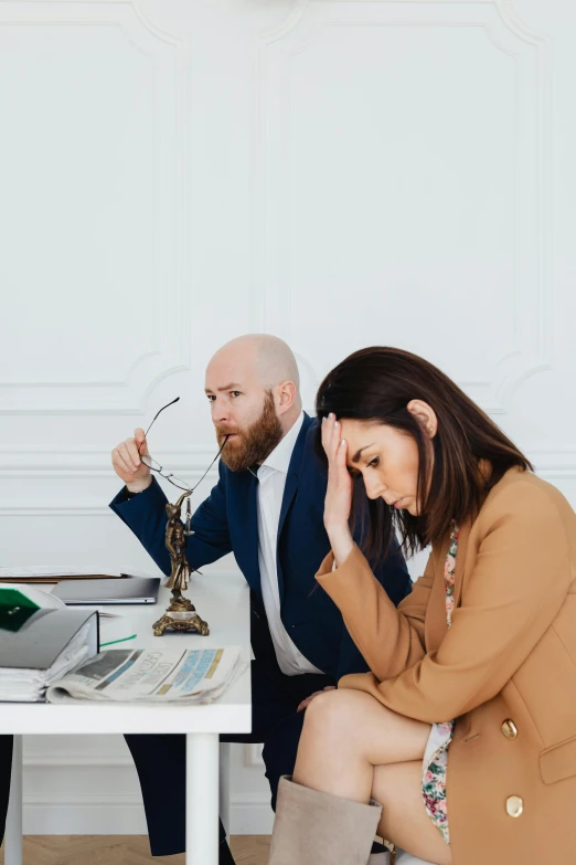 two people are seated at a table looking in the same direction