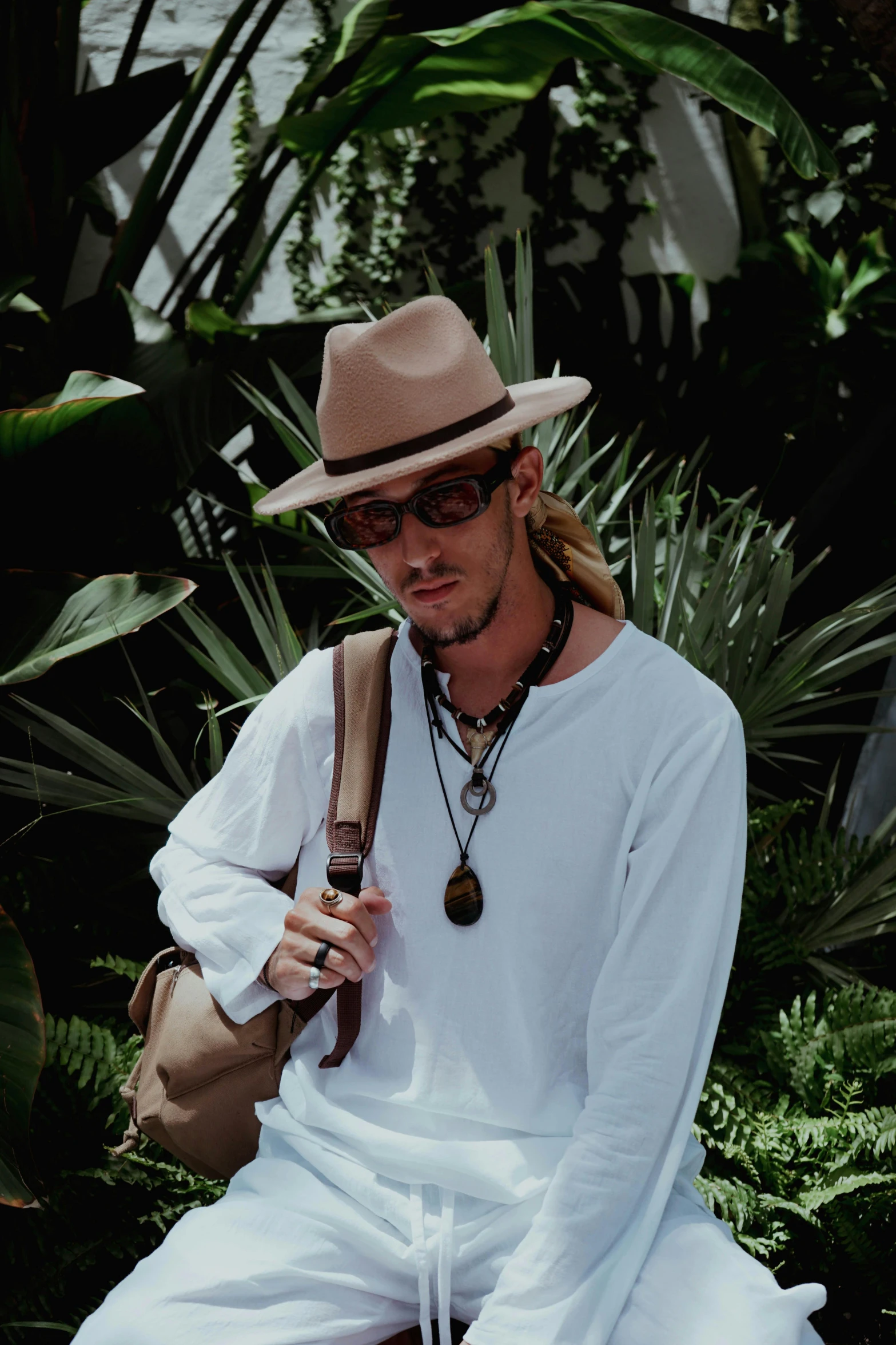 a man sitting on a ledge with his hat in his hand