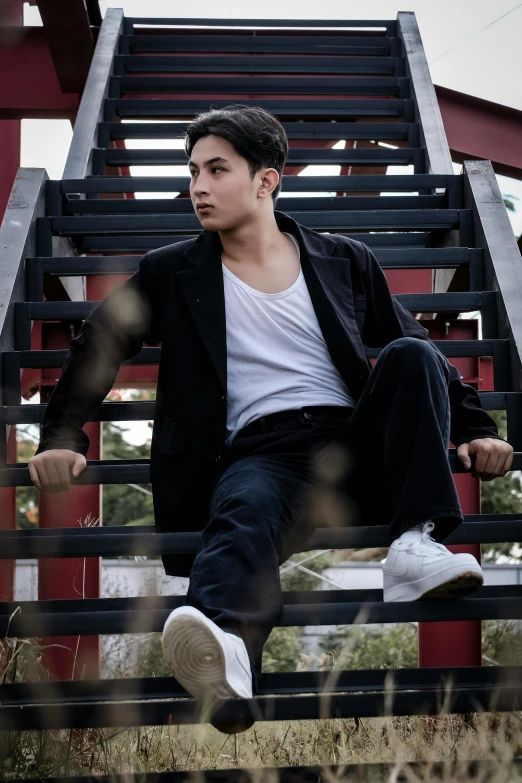 a man in a suit sitting on a metal bench