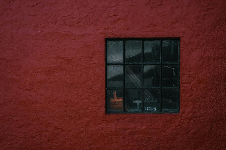 a window with red painted walls in the dark