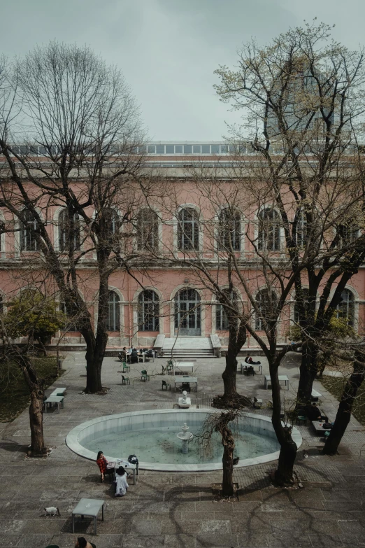 two people sitting by the courtyard near a large building