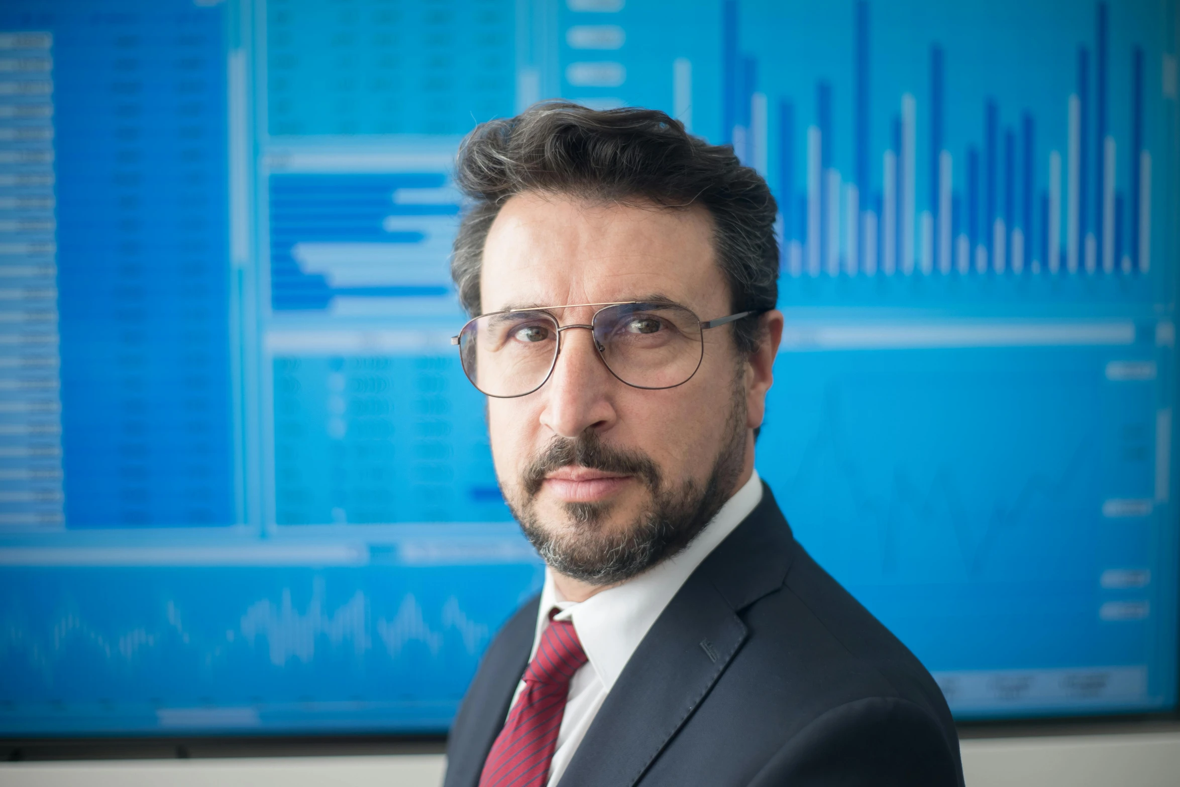 a man wearing glasses and a red tie