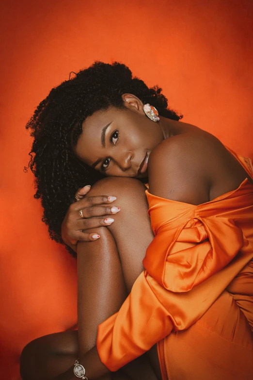 a woman poses for a portrait in an orange dress