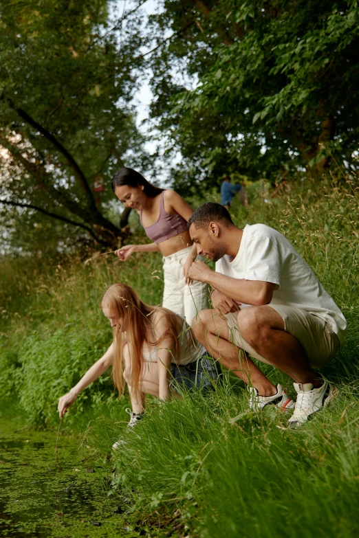two adults and one child sitting in the grass