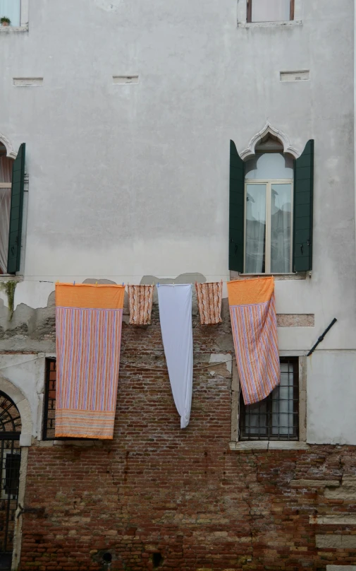 a laundry line with clothes on them on a brick wall