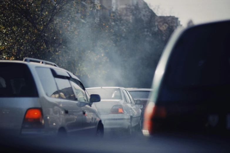 a number of vehicles on a street near some trees