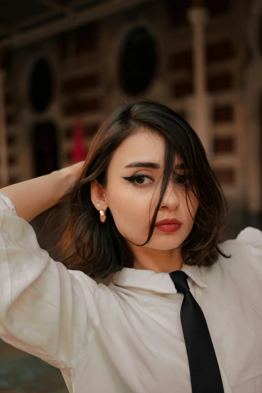 woman in white shirt and tie looking down