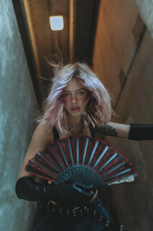 a woman wearing black holds an oriental fan and looks up at the sky