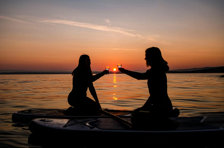 a couple of women are toasting on a boat