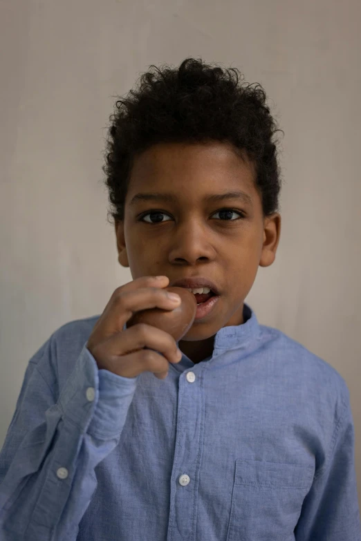 a young person in blue shirt and shirt brushing his teeth