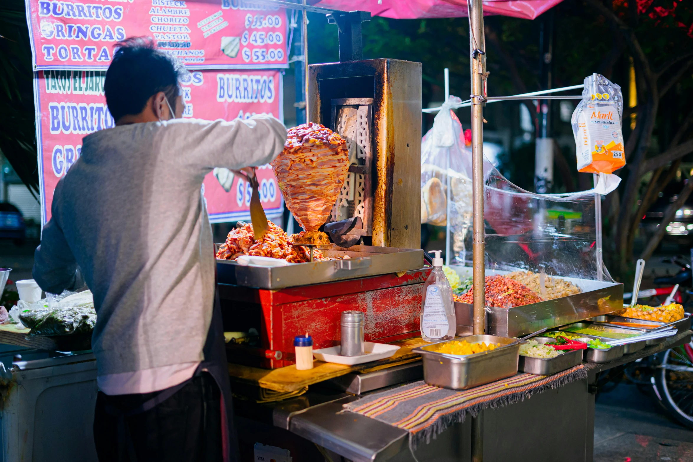 a man in a white shirt preparing food on a grill