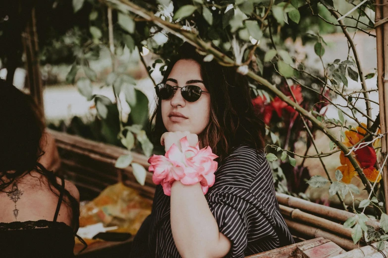 a woman holding flowers next to some people