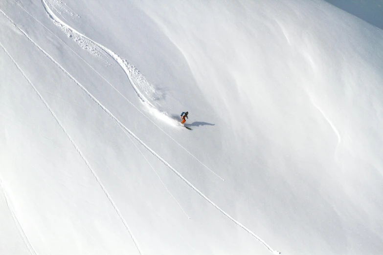 a skier skiing down a steep slope of snow