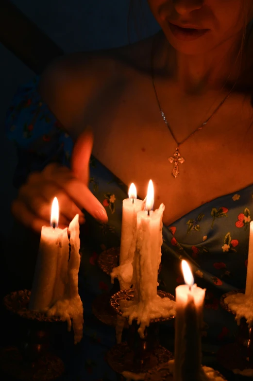 an image of a woman holding candles that look real