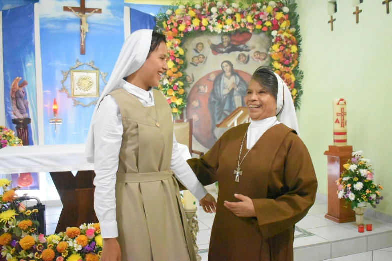 two women standing side by side in front of a church alter