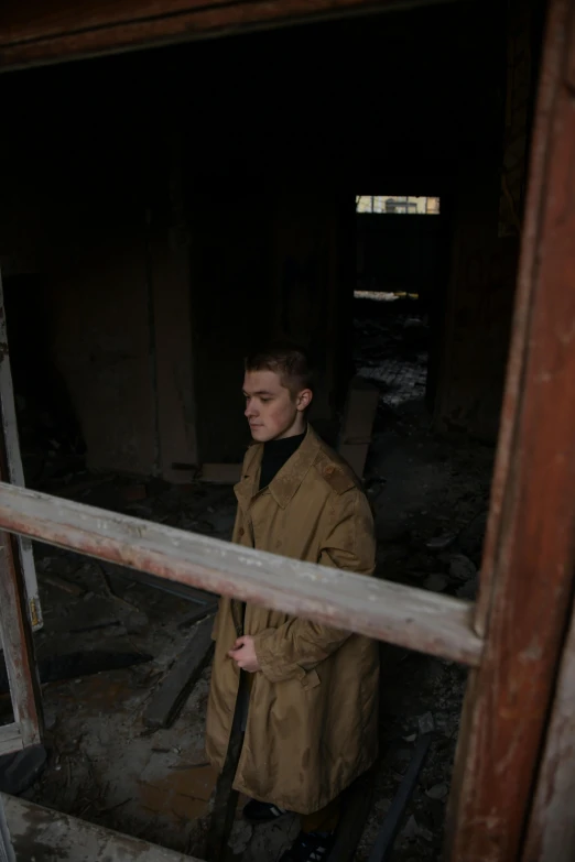 the man is walking by in an old rundown barn