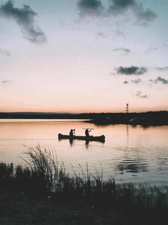 two people are canoeing in the calm lake