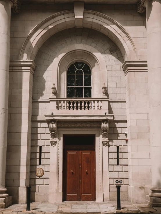 an arched doorway with a brown wooden door