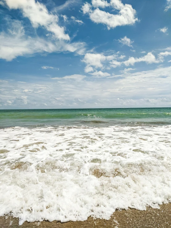 some white waves and blue sky with clouds