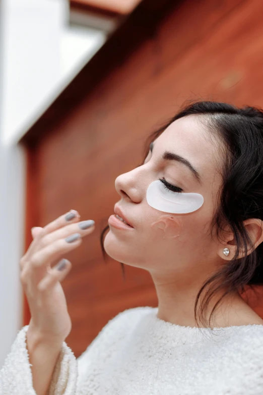 a woman is putting on a makeup powder