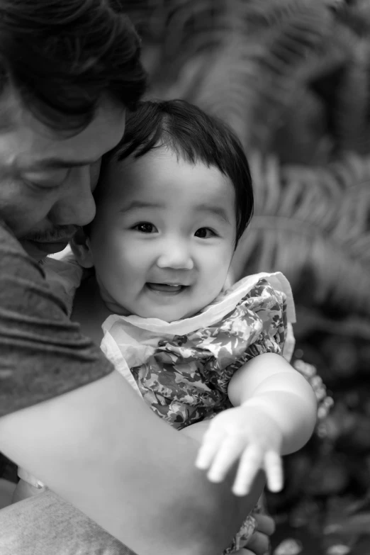 father and baby pose with their hands together