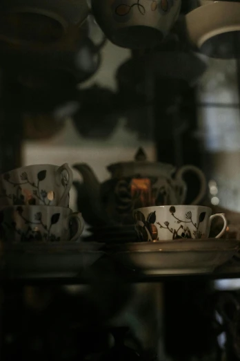 tea cups and saucers sitting on a shelf