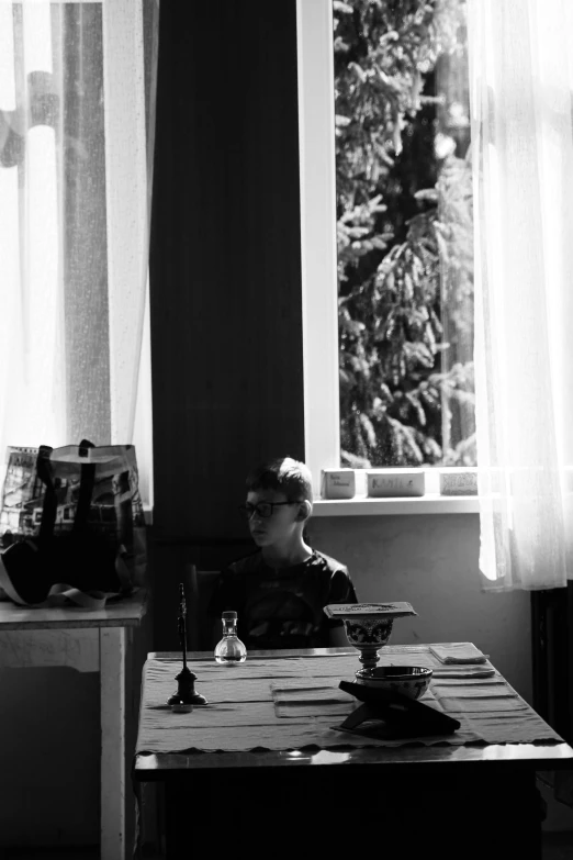 a man sitting at a table looking out a window