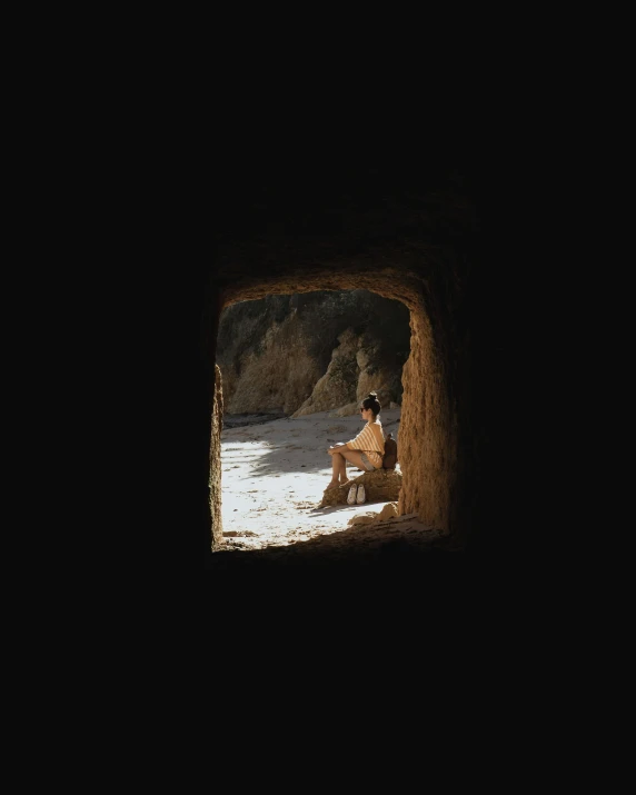 a person sitting on top of a beach in the dark