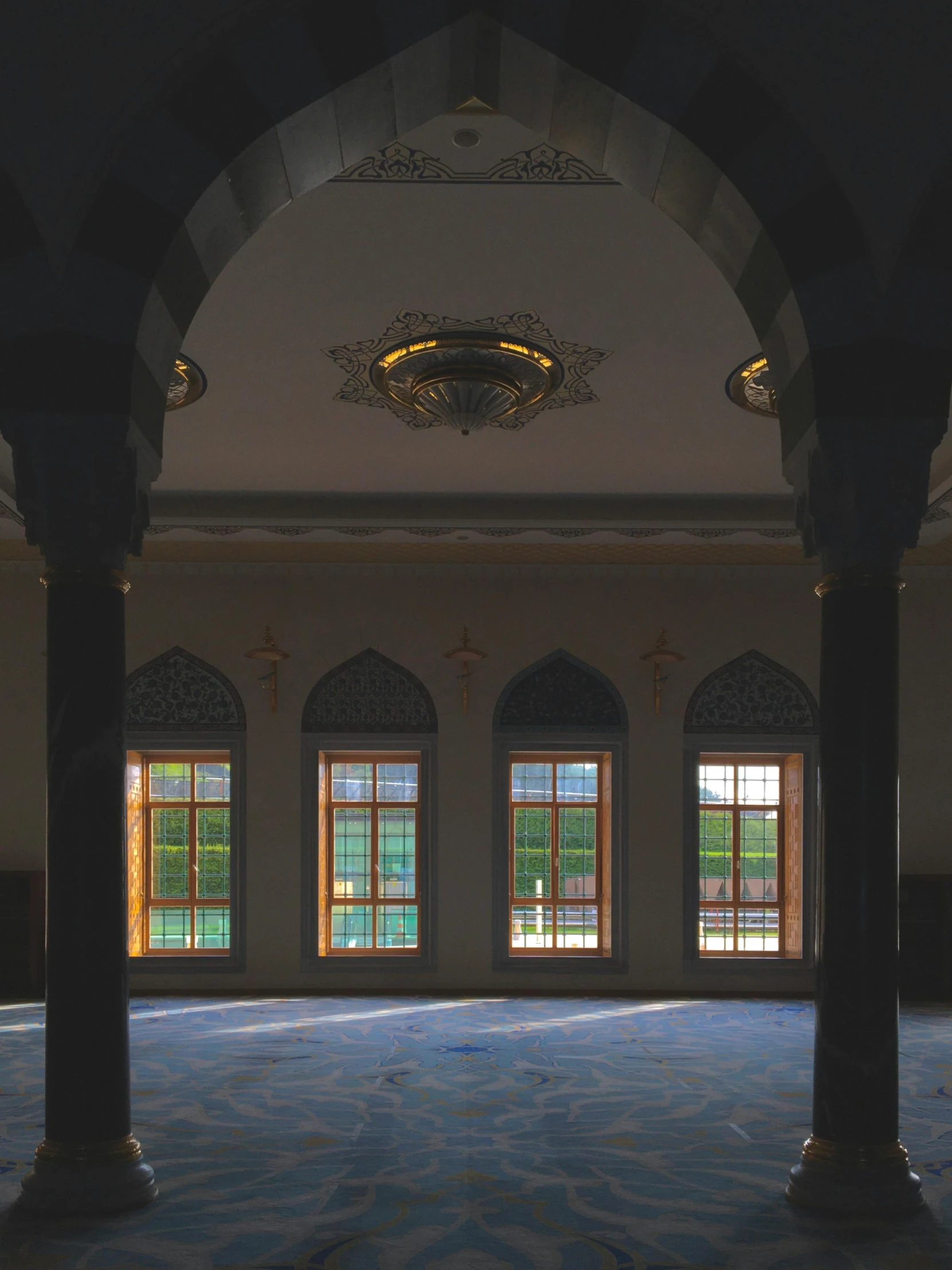 some pillars some windows and a clock on the wall