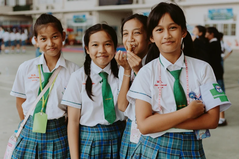 three girls in school uniforms are posing for a po