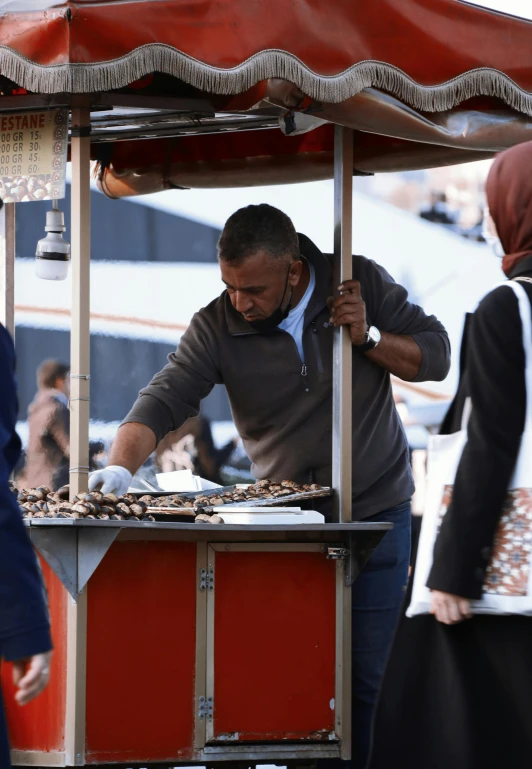 an older man is standing behind a buffet for food