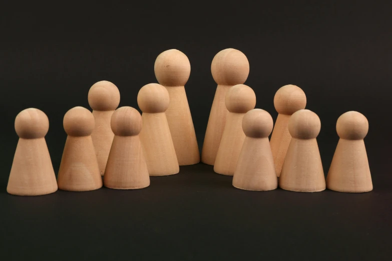 six wooden peg soldiers on a black background