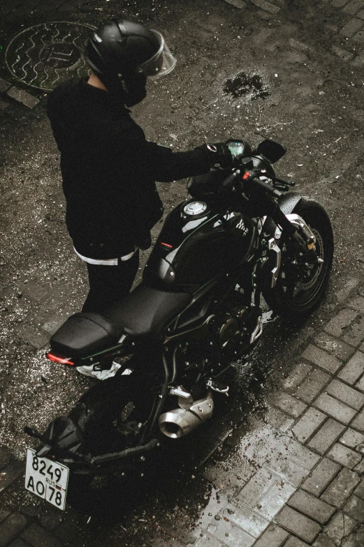 person in black jacket standing next to a parked motorcycle