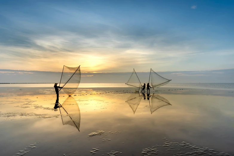 the sun is shining over the water with two people holding out nets