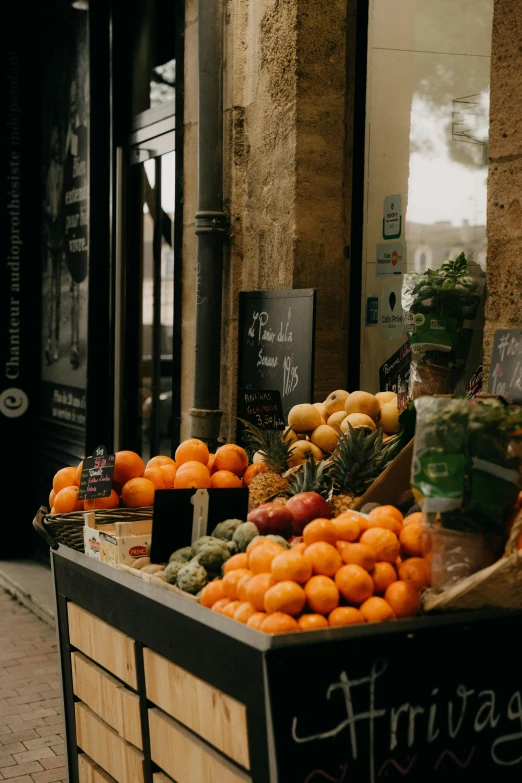 a fruit stand with lots of fruits next to a building