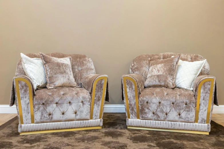 two luxurious looking chairs with gold accents