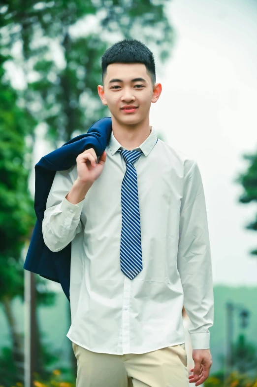 young man in white shirt and blue tie in park