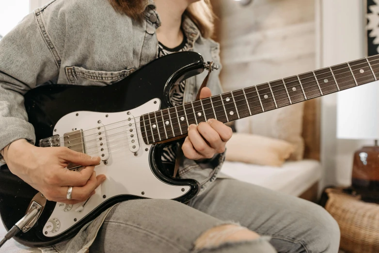 a man sitting in a chair playing an electric guitar