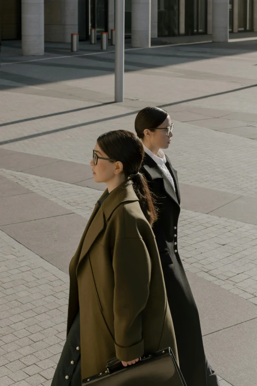 two ladies carrying bags walking on the sidewalk