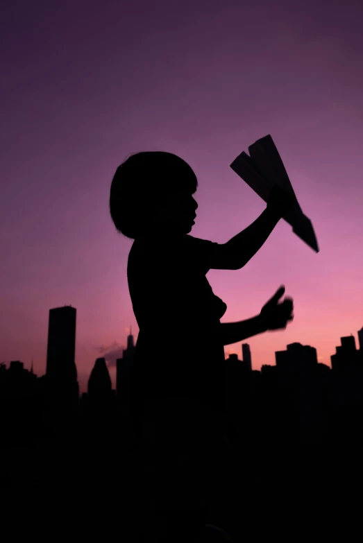 a little girl playing with a paper airplane