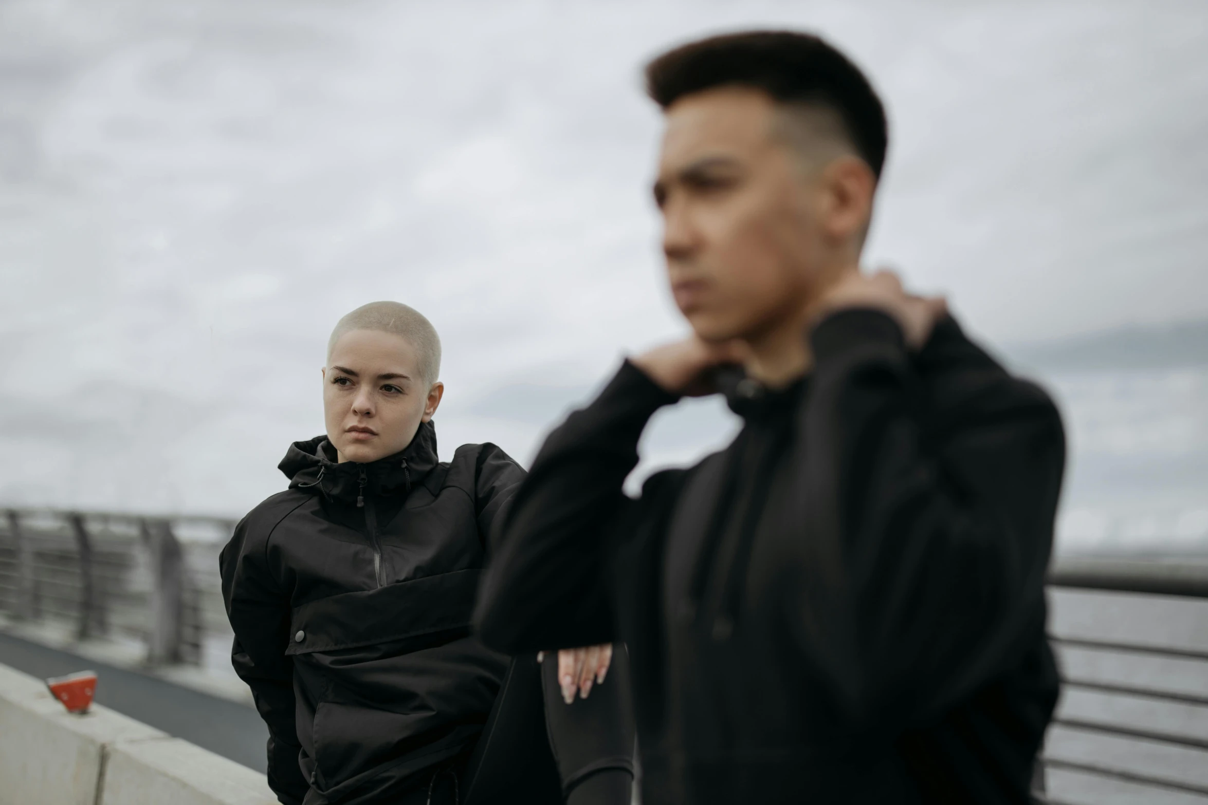 a man standing next to a woman on a bridge