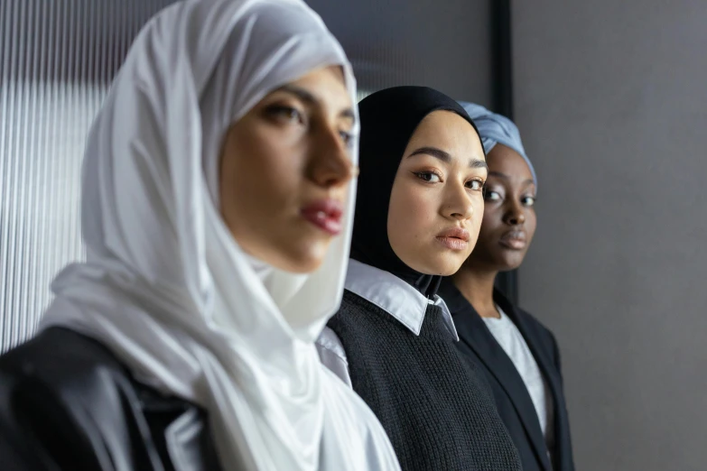 three young women standing against a wall