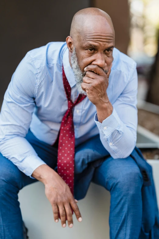 a man is sitting and he is wearing a tie