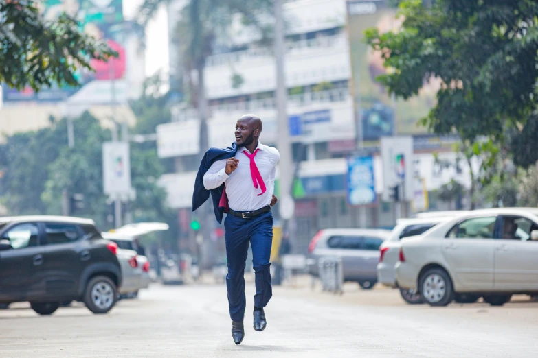 the young man wearing a red neck tie is crossing the street