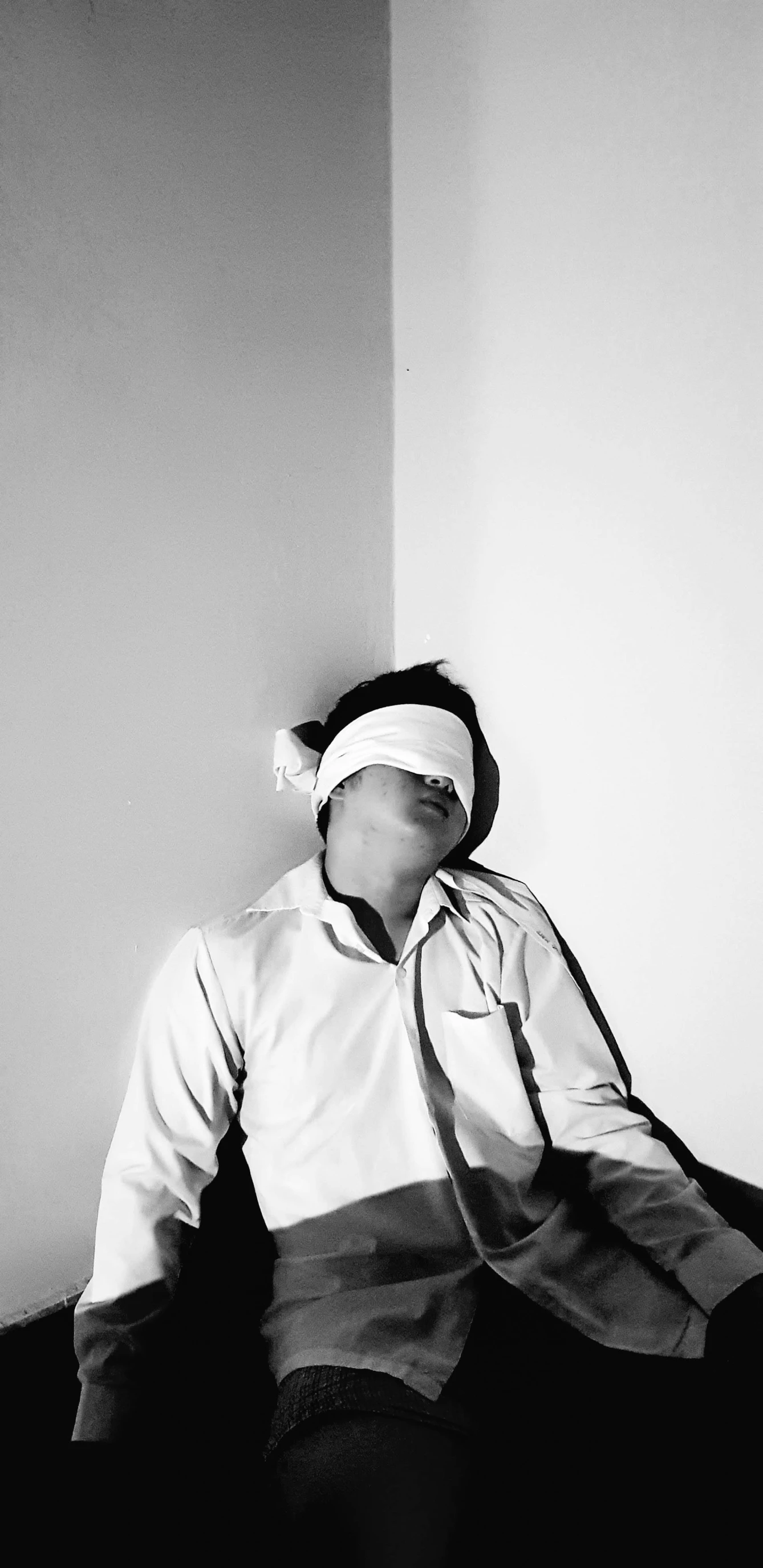 a person sits with a blind folded on their head