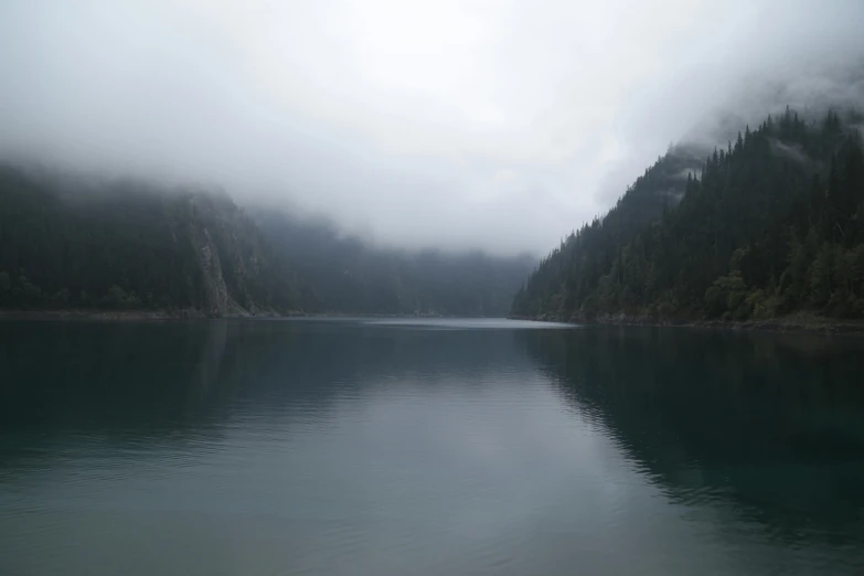 the lake is very calm in the middle of the wilderness