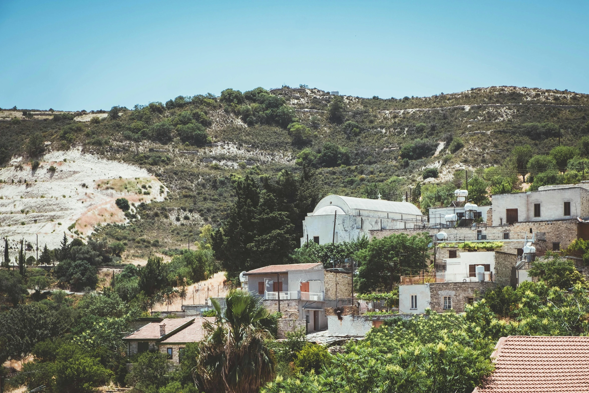 houses on a hillside with a nice sky