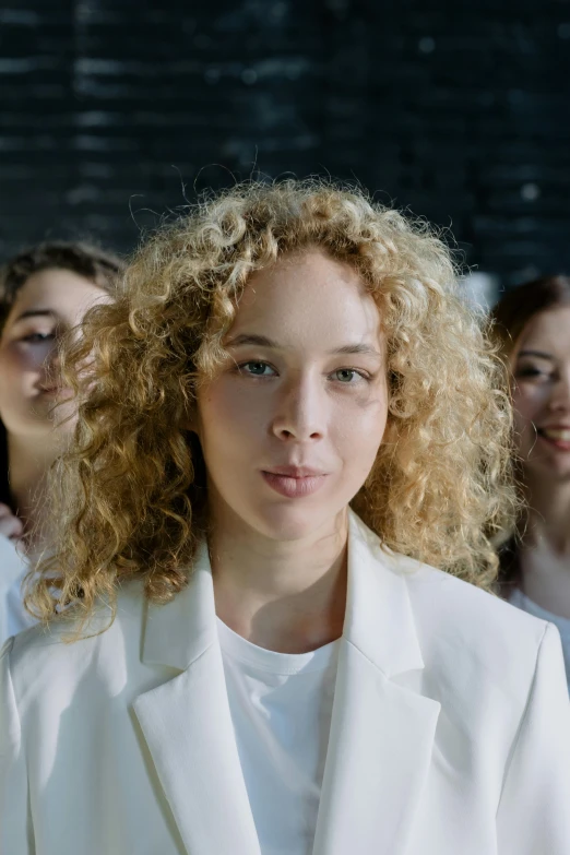 woman in white suit with long curly hair