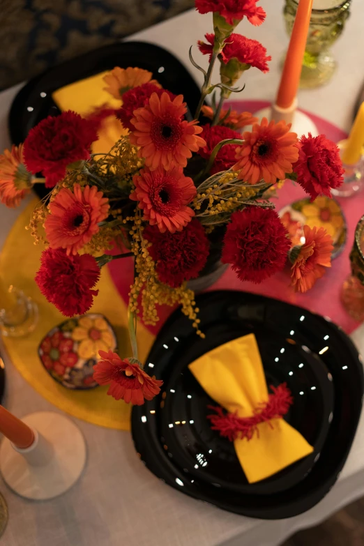 the centerpiece has been adorned with red carnations and gold ribbons